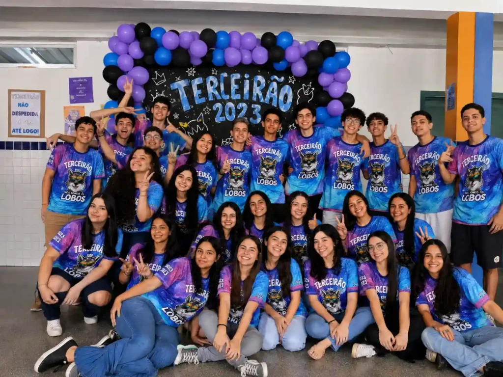 camisetas-femininas-personalizadas grupo de alunos do terceiro ano usando camisas de terceirão personalizadas coloridas com comemorando a formatura no pátio da escola